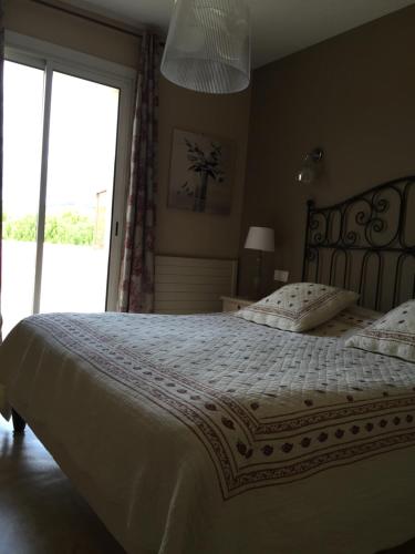 a bedroom with a bed with a white comforter and a window at Logis Hôtel Le Manoir & Lounge in Apt
