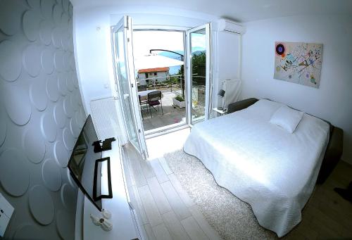 a bedroom with a white bed and a sliding glass door at Apartment Livingstone in Rijeka