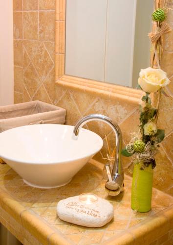 a bathroom counter with a white sink and a mirror at Gasthof Sommer in Lautertal