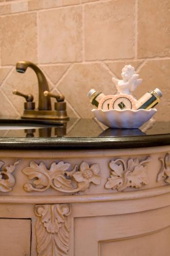 a bathroom counter with a sink with a bottle of champagne at Gasthof Sommer in Lautertal