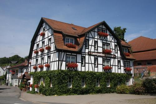 a black and white building with flower boxes on it at Gasthof Sommer in Lautertal
