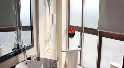 La salle de bains est pourvue de toilettes, d'un lavabo et d'un téléphone. dans l'établissement GreenTree Inn Linyi Bus Station, à Linyi