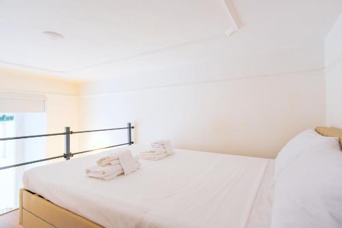 Un dormitorio blanco con una cama con toallas. en Elegantis Pompeo Magno Suite Apartment - Historic Center near the Vatican and Piazza del Popolo, en Roma