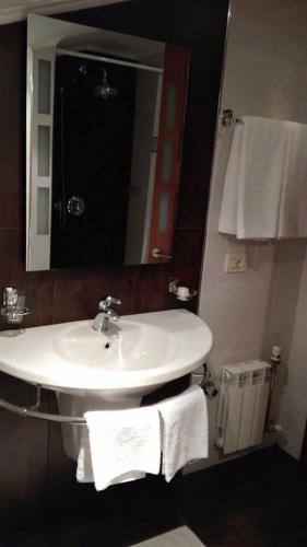 a bathroom with a sink and a mirror and towels at Vila Sigal Pogradec in Pogradec