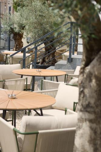 an outdoor cafe with tables and chairs and trees at Penzion Ohnysko in Trnava