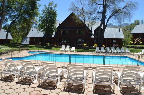 a group of chairs sitting next to a swimming pool at Añañucas III in Las Trancas