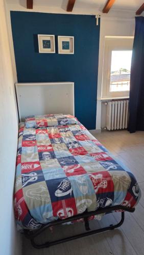 een slaapkamer met een bed met een dekbed erop bij Casa Elsa in Torri del Benaco