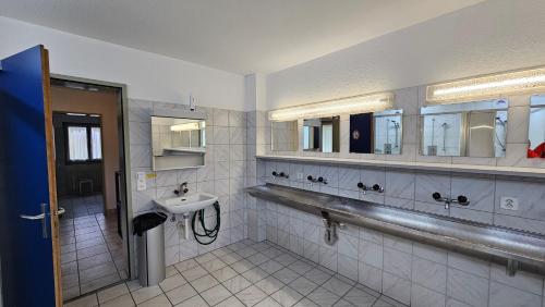 un bagno con lavandino e specchio di Unterkunft Zwisa a Jenaz