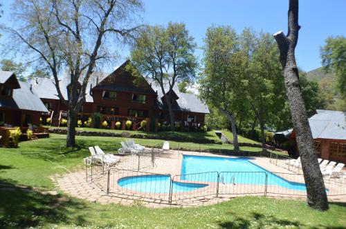 a swimming pool in front of a large house at Añañucas III in Las Trancas