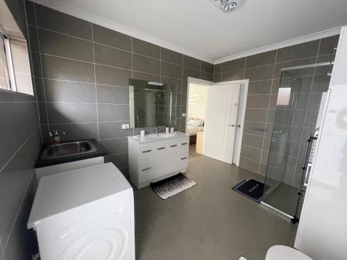 een badkamer met een toilet, een wastafel en een douche bij Serene Guest House in Callala Beach