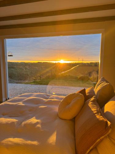 a bedroom with a bed and a window with the sunset at Studio34 in Hauwert