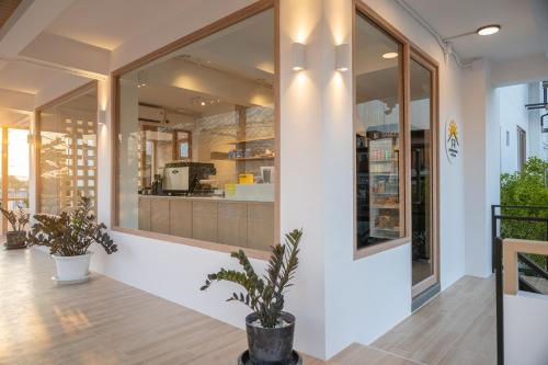 een winkelpui met grote ramen en een potplant bij Morning Place in Ban Krathum Lom