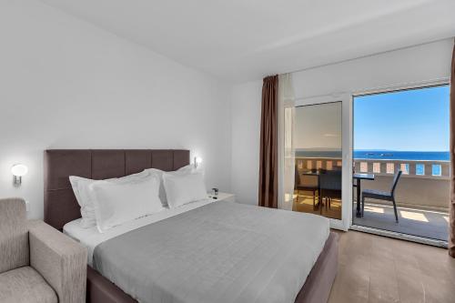 una camera da letto con un letto, una sedia e una finestra di Villa Jasna a Tučepi