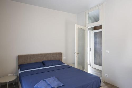 ein weißes Schlafzimmer mit einem blauen Bett und einem Fenster in der Unterkunft Casa Celeste in Pella