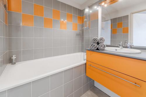 een badkamer met een ligbad en een wastafel bij Agréable studio avec piscine à 2 mins de Montpellier in Juvignac