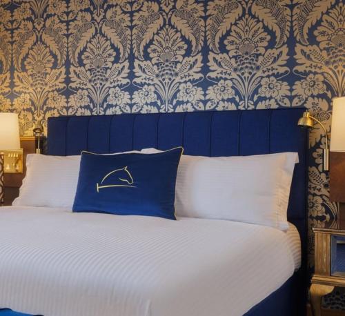 Una cama azul y blanca con un papel tapiz azul y blanco. en Polo Club - Hotel, en Ufton