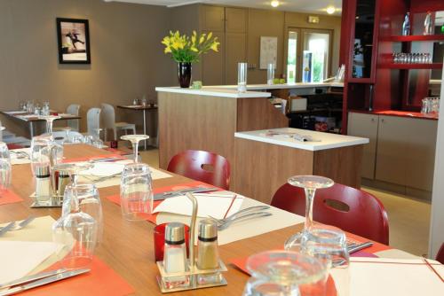 a restaurant with a long table with wine glasses on it at Campanile Bourg-En-Bresse ~ Viriat in Viriat