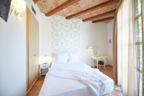 バルセロナにあるアパート スイート オステンプロの白いベッドルーム(ベッド1台、テーブル付)