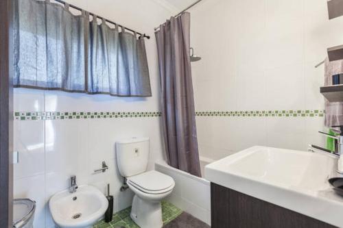 ein weißes Badezimmer mit Toilette und Waschbecken in der Unterkunft Carvalhosa Apartment in Monte