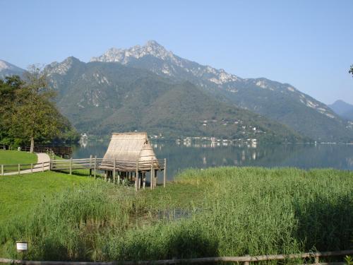 a dock on a lake with mountains in the background at Hotel Cima d'Oro in Ledro