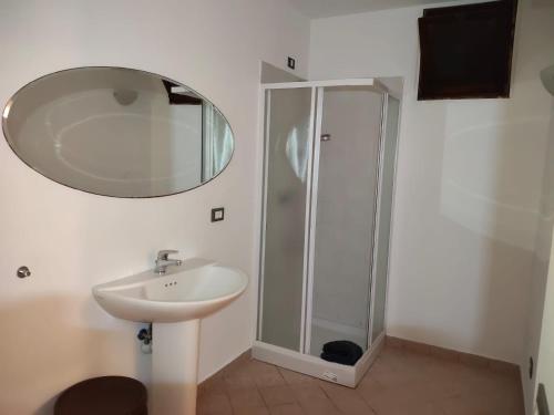 een badkamer met wastafel en douche met spiegel bij Casa Chicken2 -Mare, Monti E Bikers in Bardino Vecchio