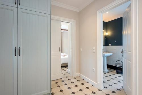a bathroom with white cabinets and a bathroom with a sink at Nancy Luxury Suites in Kassiopi