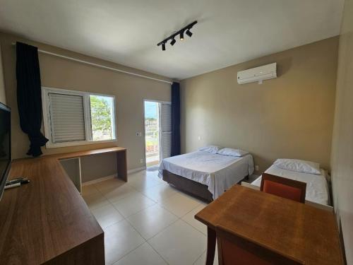 una habitación de hotel con dos camas y una mesa en Suíte privativa próxima ao Sesc 1, en Bertioga