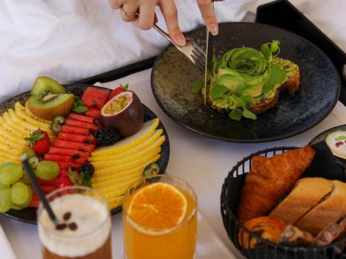 een tafel met twee borden eten en een persoon die een vork vasthoudt bij Hôtel Bel Ami in Parijs