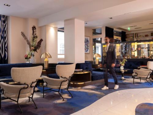 een man loopt door een hotellobby bij Hôtel Bel Ami in Parijs