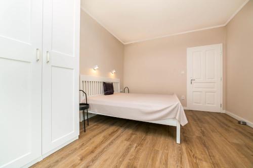 a bedroom with a white bed and a wooden floor at New apartment 6 - self check in, free parking in Bratislava