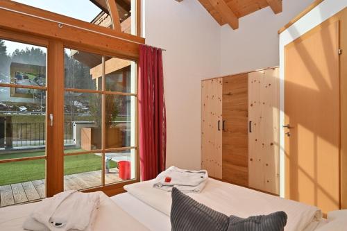 a bedroom with two beds and a large window at Apartment Zugspitze in Biberwier