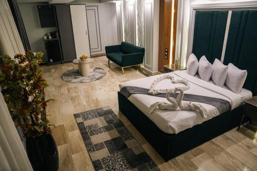 Un dormitorio con una cama grande y una silla azul. en Grand Hotel Port Said, en Puerto Saíd