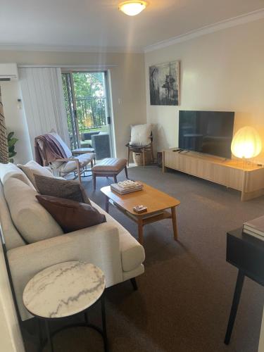 a living room with a couch and a fireplace at 2 Bed Ground Flr Gaythorne Courtyard Apt, parking in Brisbane