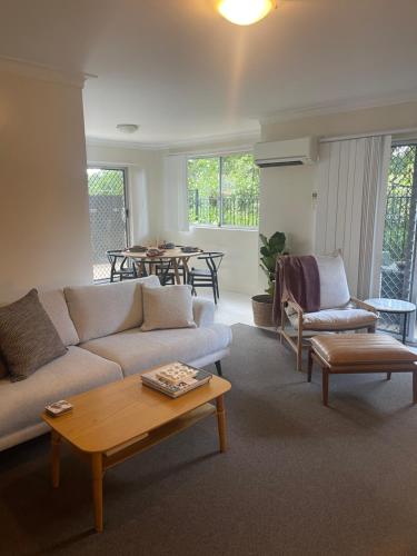 a living room with a couch and a table at 2 Bed Ground Flr Gaythorne Courtyard Apt, parking in Brisbane