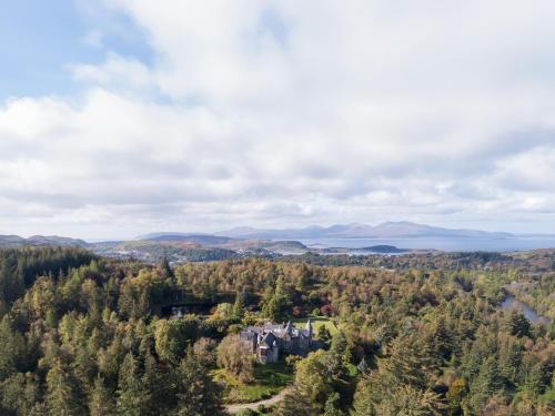 an aerial view of a castle in the middle of a forest at Glencruitten House in Oban