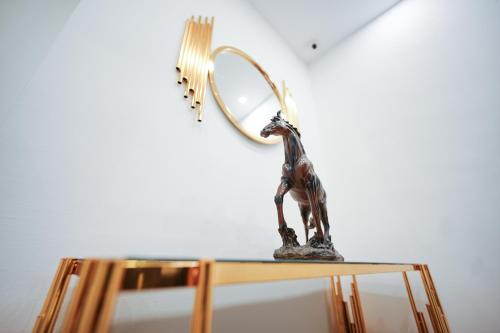 brązowa statua żyrafy na stole z lustrem w obiekcie Corner View Hotel w mieście Wadi Musa