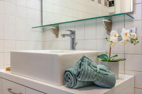 een wastafel in de badkamer met een handdoek en een plant op het aanrecht. bij Cozy apartment in Castelfranco Veneto