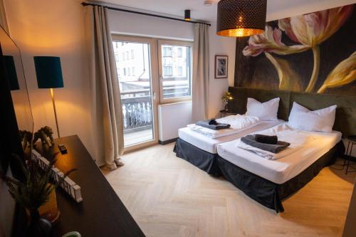 una camera d'albergo con due letti e una grande finestra di Appartements Cafe Schneider a Sankt Anton am Arlberg