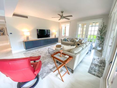 a living room with a couch and a red chair at Villa Kismet - Beachfront community with 3 pools in Brenas