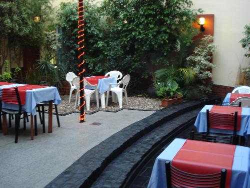 um conjunto de mesas e cadeiras num jardim em Hotel Esperia em Buenos Aires