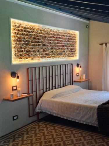 una camera da letto con un letto e un muro di mattoni di Los horneros a General Rodríguez