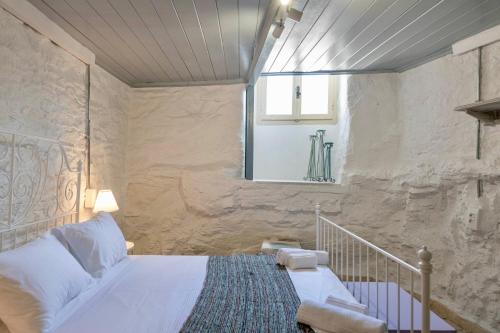 a bedroom with a bed and a window at Hermia Mansion in Ermoupoli