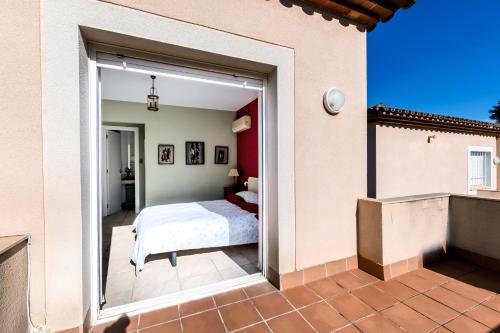 - une chambre avec une grande porte en verre menant à un lit dans l'établissement Al Alba - Serene escape with shared swimming pool, à Bonmont Terres Noves