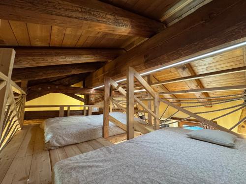 een slaapkamer met 2 bedden op een houten zolder bij Baita Mot in Marmora