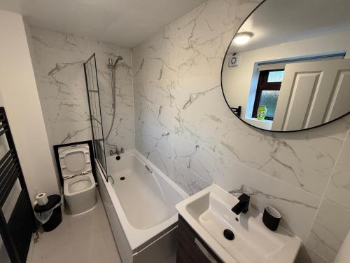 a white bathroom with a sink and a mirror at New 4 Bed House Sleeps up to 8 People in Chepstow