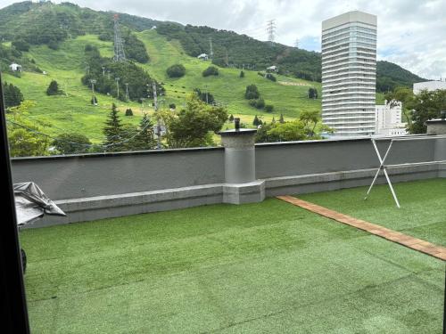 een balkon met uitzicht op een groene heuvel bij Powder Base Naeba in Yuzawa