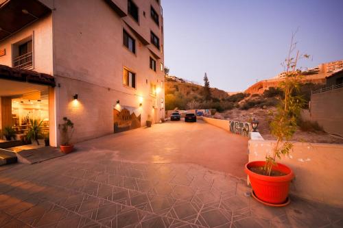 ein leerer Innenhof mit einem Gebäude und einer Topfpflanze in der Unterkunft Corner View Hotel in Wadi Musa