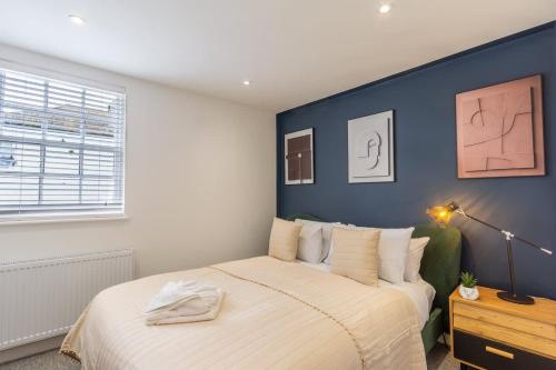 a bedroom with a bed with a blue accent wall at Albion at the Level - 2 BD Flat in Brighton & Hove
