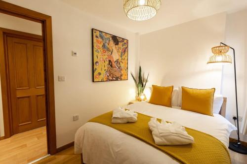 a bedroom with a large white bed with yellow pillows at Elegance at the Lanes-3BD in Brighton & Hove