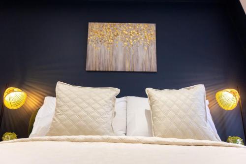 a bedroom with a white bed with two pillows at Regent Grand Penthouse in Brighton & Hove